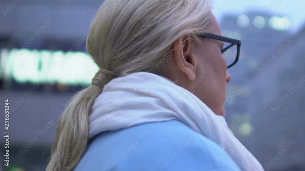 Elderly female walking city, modern attractive woman on urban street, promenade Elderly female walking city, modern attractive woman on urban street, promenade