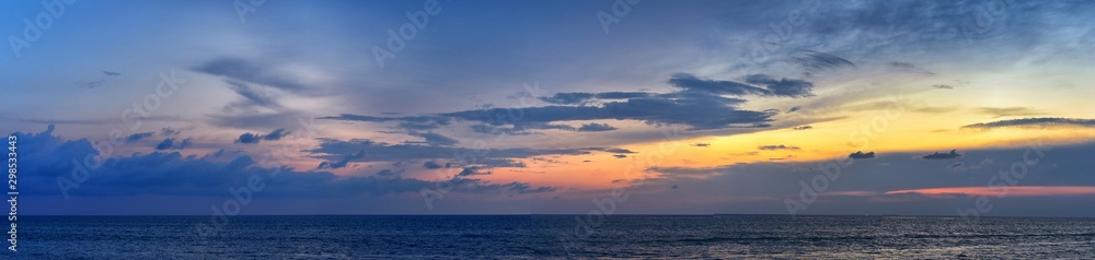 Phuket beach sunset, colorful cloudy twilight sky reflecting on the sand gazing at the Indian Ocean, Thailand, Asia.