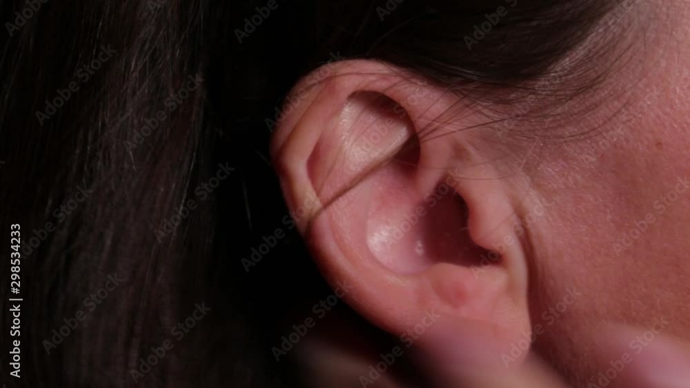 Woman right ear. Macro extreme close up view of female ear. Concept for audio music sound health human ear. Woman tapping his ear Woman right ear. Macro extreme close up view of female ear. Concept for audio music sound health human ear. Woman tapping his ear
