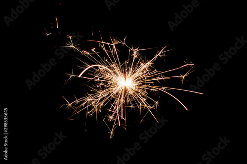 burning sparkler and flying sparks on a black background  festive sparkler
