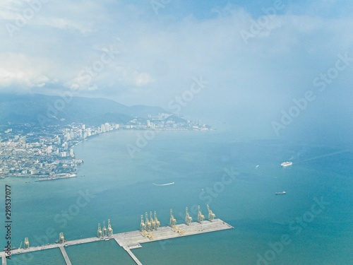 Aerial view coastal city and pier with cranes 