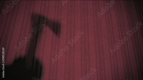 Vintage effect. A man kills his victim with an ax. old, glitch, retro, Murder. Shadow of the criminal on the wall. Halloween. The room is flooded with red light. Scene from a horror movie. Killer.