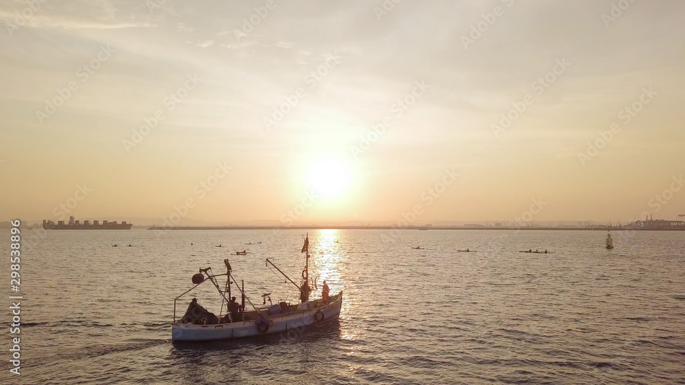 Fishing boat on the background of golden sunrise. 
