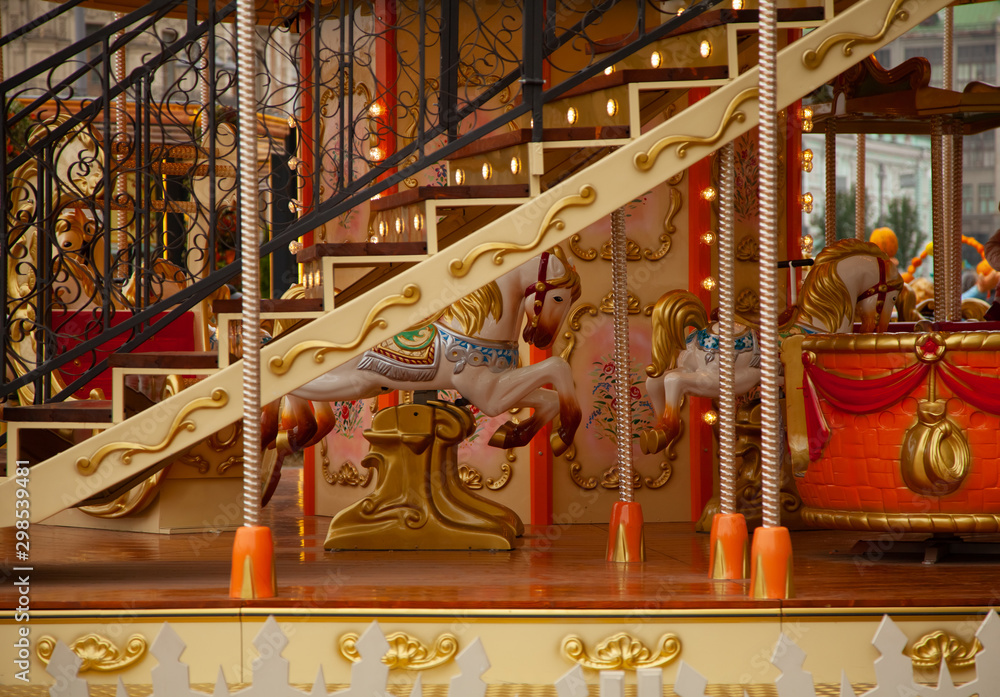 Fototapeta premium Old carousel with horses in a holiday autumn evening park with nobody