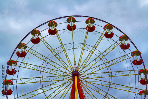 Ferris wheel on a background of cloudy autumn sky.
