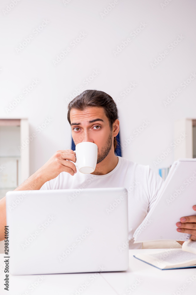 Young male student preparing for exams at home Young male student preparing for exams at home