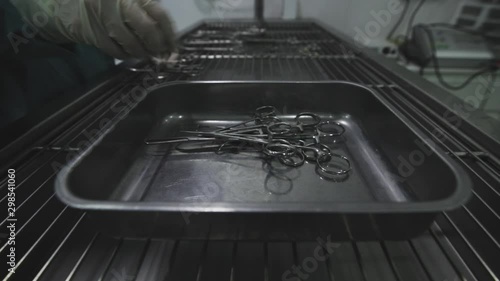 veterinarian surgeon collecting surgical material after an operation of an animal