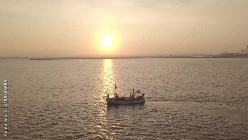 Fishing boat on the background of golden sunrise. Birds are crossing above against the sun. Fishing boat on the background of golden sunrise. Birds are crossing above against the sun.