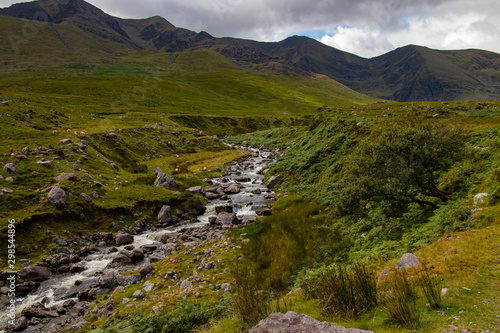 Nearby Carrantuohill Mountain  way to the pick  river and road  Co. Kerry  Ireland summer