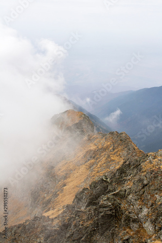 Fagaras mountains-view from Vanatarea lui Buteanu peak. Fagaras mountain range covered with clouds from Romanian Carpathian mountains