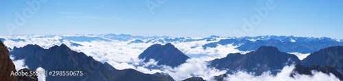 Fototapeta Naklejka Na Ścianę i Meble -  Wide angle View of Mountain peaks raising out of the cloud line