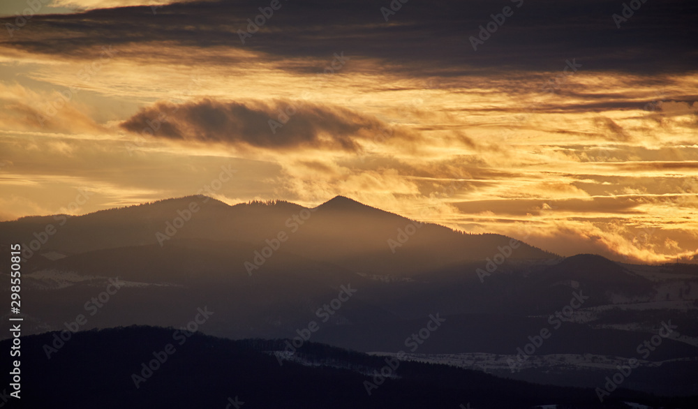 Apuseni mountains at sunset in golden light and in silhouette