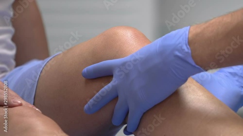 Doctor palpating patient knee, traumatologist examination after trauma, health photo