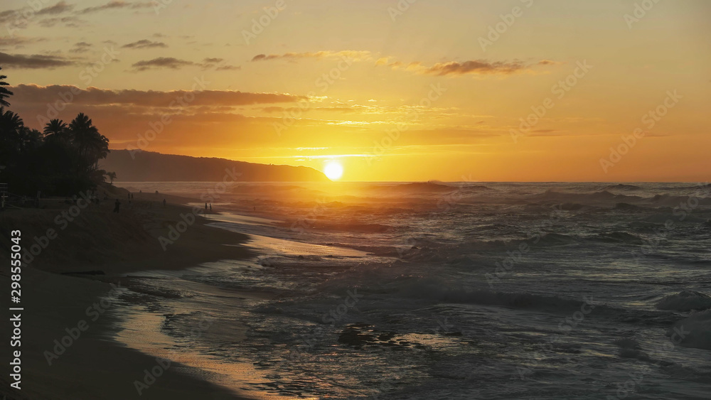 wide view of the sun setting at the tip of kaena point in hawaii