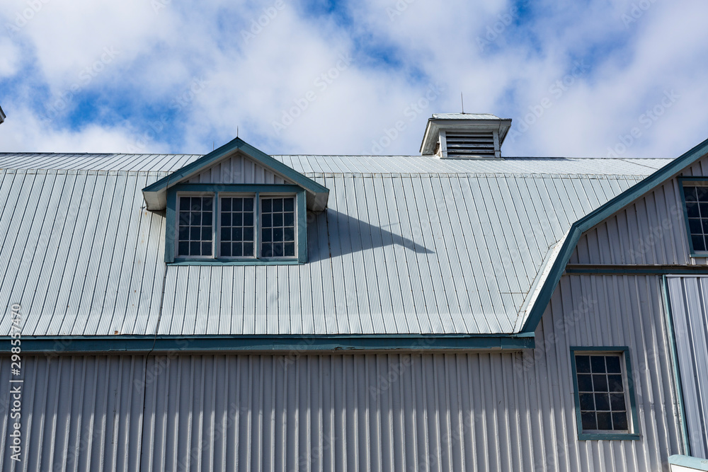 Steel barn with lines, windows and a blue sky