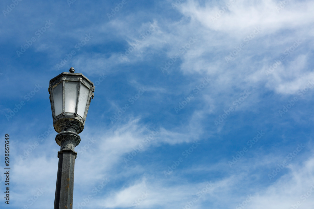 Single street lamp against a blue sky with clouds