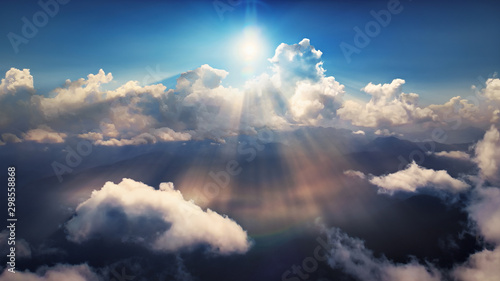 Fototapeta Naklejka Na Ścianę i Meble -  Flying through heavenly beautiful sunny cloudscape. Amazing of golden fluffy clouds moving softly on the sky and the sun shining above the clouds with beautiful rays and lens flare.