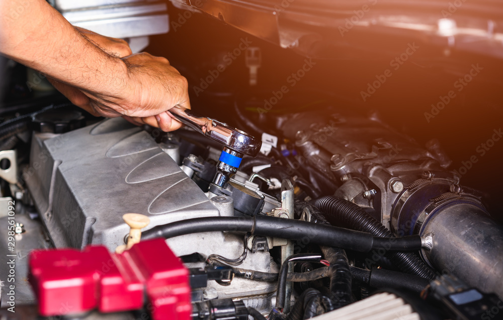 Hand of auto mechanic technician service engine and using wrench socket