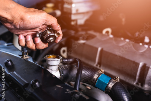 Hand of auto mechanic technician service check cooling water photo