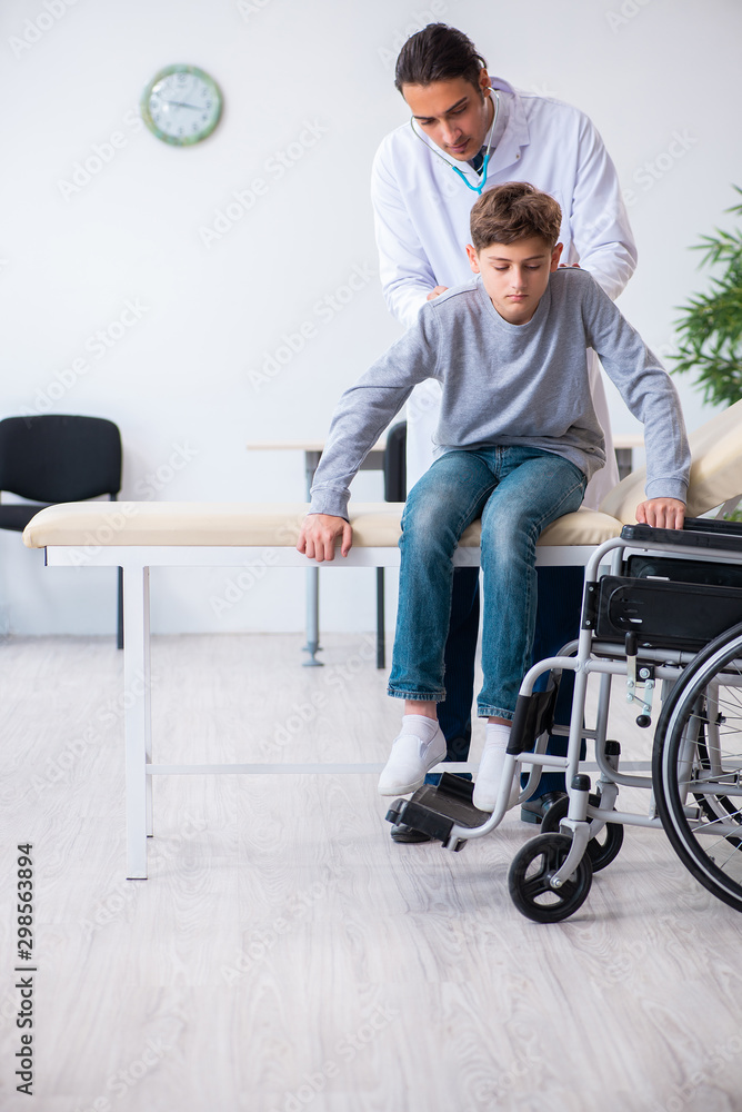 Young male doctor pediatrist and boy in wheel-chair Young male doctor pediatrist and boy in wheel-chair