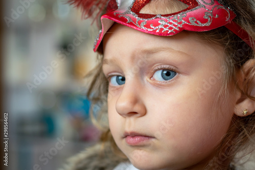 portrait of little girl wearing a mask on her forehead 