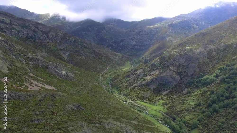 Stream in a valley with cloudy sky aerial shot Stream in a valley with cloudy sky aerial shot