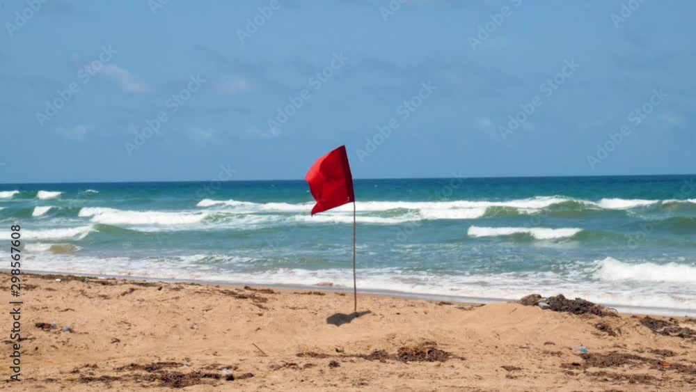 Red life guard flag on a beach in the Caribbean Red life guard flag on a beach in the Caribbean