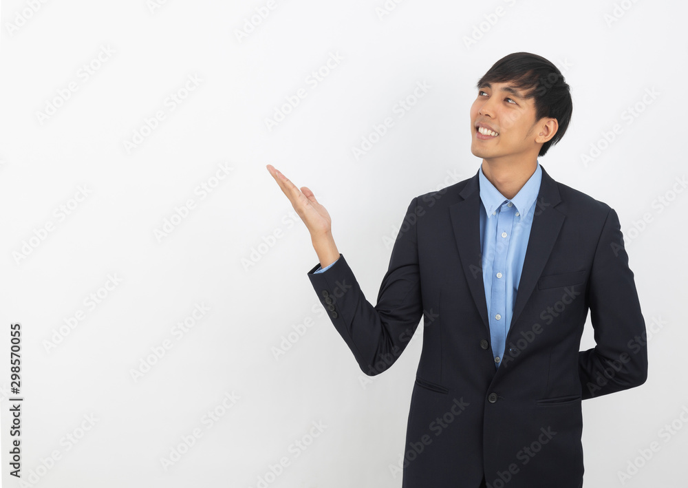 Young asian business man pointing to the side with a hand to present a product or an idea while looking forward isolated on white background. Young asian business man pointing to the side with a hand to present a product or an idea while looking forward isolated on white background.