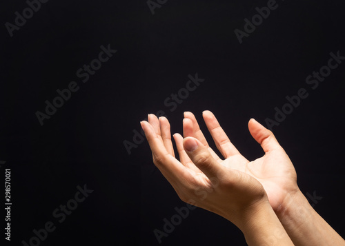 Praying hands in the dark background with faith in religion and belief in God.