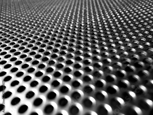 Holes of grey metal plate with round regular holes texture background.