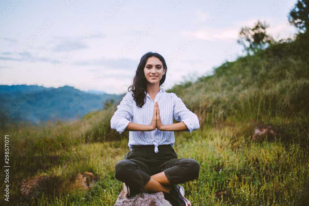 Beautiful woman practice doing yoga on rock at outdoor,Hands respect,Positive thinking