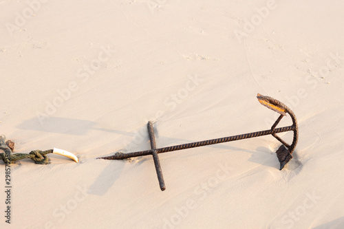 Old anchor on the sandy beach