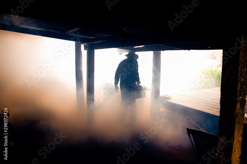 A man use fumigation mosquitoes machine for kill mosquito carrier of Zika virus and dengue fever prevention outbreak in school at the rainy season.Soft and blur focus. photo