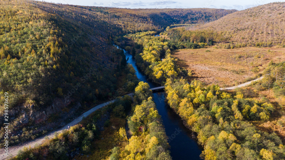 Obraz premium Top view of the taiga forest, river, road . The vast expanses of Eastern Siberia. far East Russia