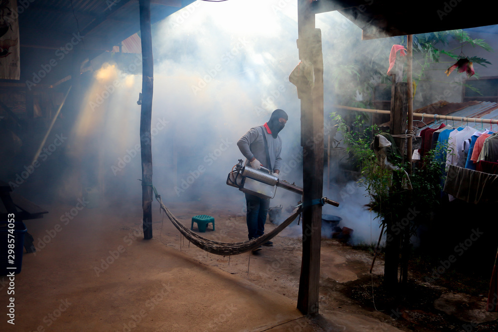 Obraz premium A man use fumigation mosquitoes machine for kill mosquito carrier of Zika virus and dengue fever prevention outbreak in school at the rainy season.Soft and blur focus.