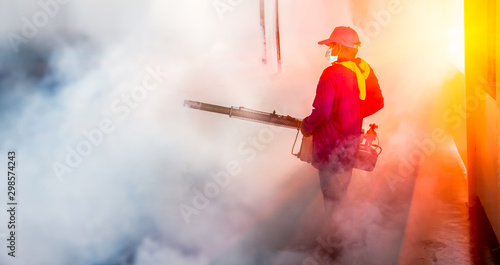 Fotografi A man use fumigation mosquitoes machine for kill mosquito carrier of Zika virus and dengue fever prevention outbreak in school at the rainy season