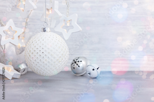 new year decorations on wooden background. light garlands in form of stars and glass balls with jingle bells for christmas home decor 