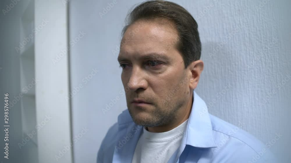 Tired man standing in hospital hall waiting for surgery finish, nervous tension Tired man standing in hospital hall waiting for surgery finish, nervous tension