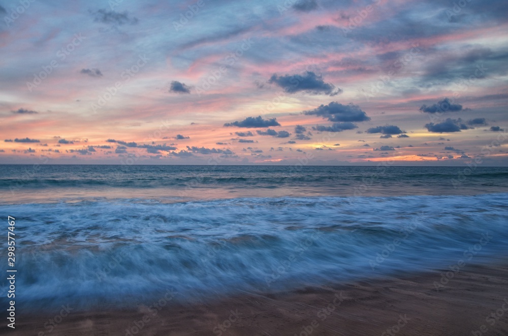Phuket beach sunset, colorful cloudy twilight sky reflecting on the sand gazing at the Indian Ocean, Thailand, Asia. Phuket beach sunset, colorful cloudy twilight sky reflecting on the sand gazing at the Indian Ocean, Thailand, Asia.