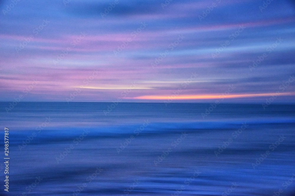 Phuket beach sunset, colorful cloudy twilight sky reflecting on the sand gazing at the Indian Ocean, Thailand, Asia.