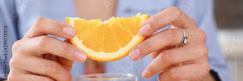 Female arms hold slides orange and glass of juice