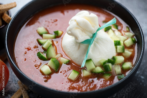 Obraz na plátně Close-up of cold tomato soup gazpacho with burrata cheese and chopped cucumber,
