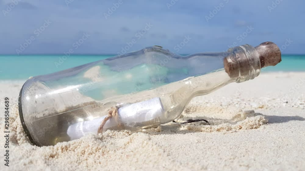 A surprising letter in a bottle came along unexpectedly in the white sand beside the cool green sea in the Philippines - steady shot A surprising letter in a bottle came along unexpectedly in the white sand beside the cool green sea in the Philippines - steady shot