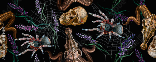 Gothic embroidery. Human skulls, lavender flowers, tarantula spider and bull head, clothes background. Horizontal seamless pattern. Halloween dark background. Fashionable template for clothes