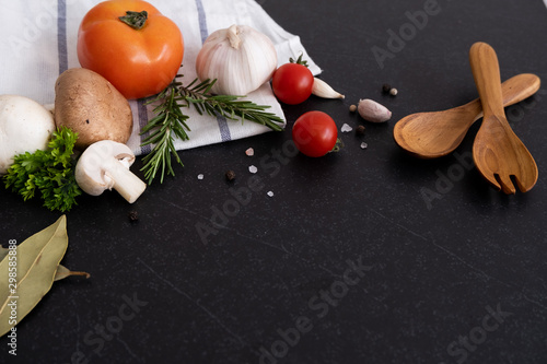 spices herbs and greens. Ingredients for cooking. Food background on black slate table. Top view copy space. Rosemary  tomatoes  garlic and peppers. - Image