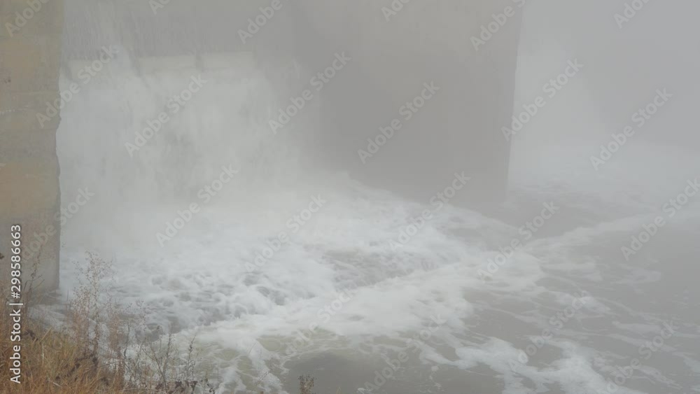 Water flow drop through the dam with fog no sun