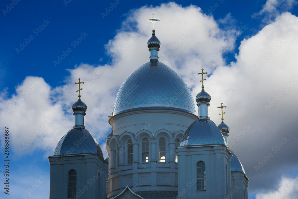Eastern orthodox crosses on gold domes againts blue sky with clouds. Russian Orthodox church.
