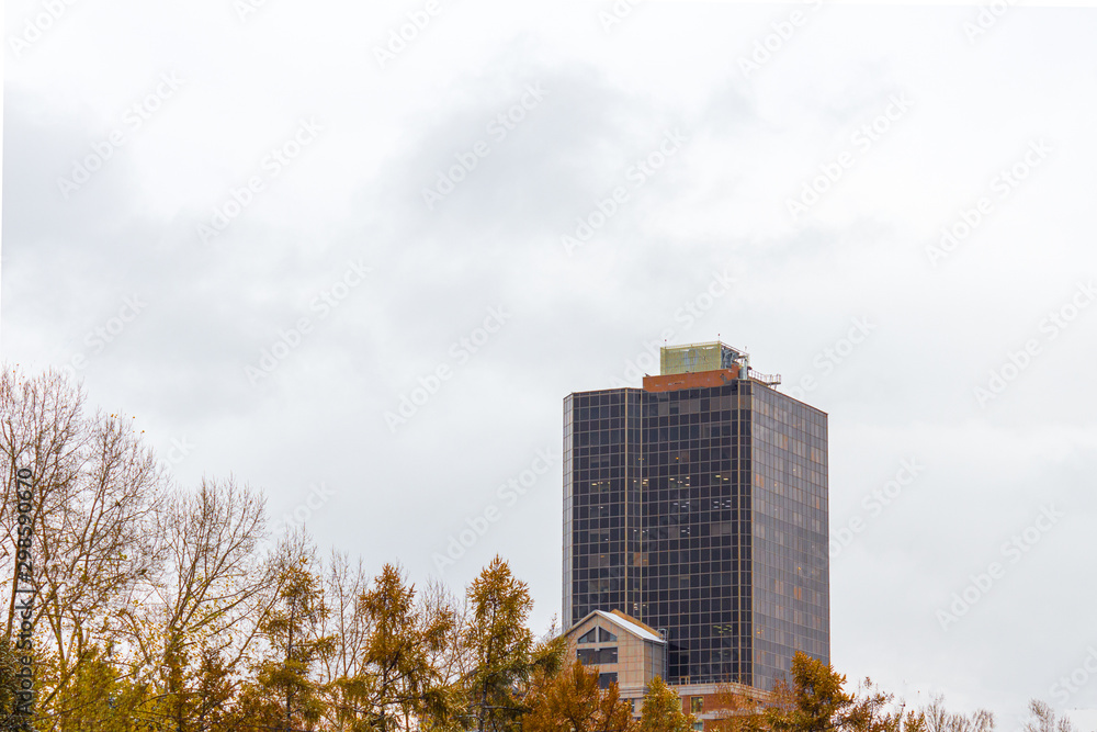High-rise glazed building against the gray sky. Photo across the Park.
