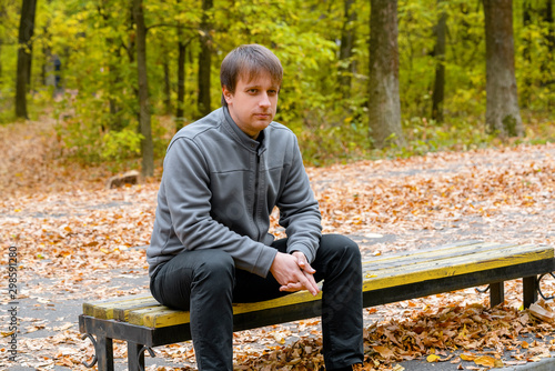 Portrait of young courageous man in autumn park