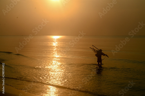 Tropical sunrise seascape with a fisherman, Thailand.